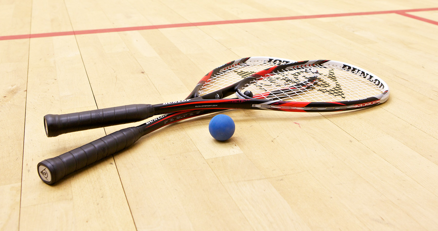 Two rackets on a squash court