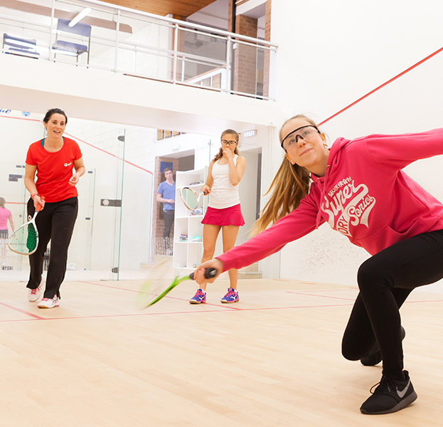 Female coach teaching young players on court