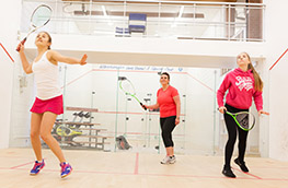 Three women playing squash