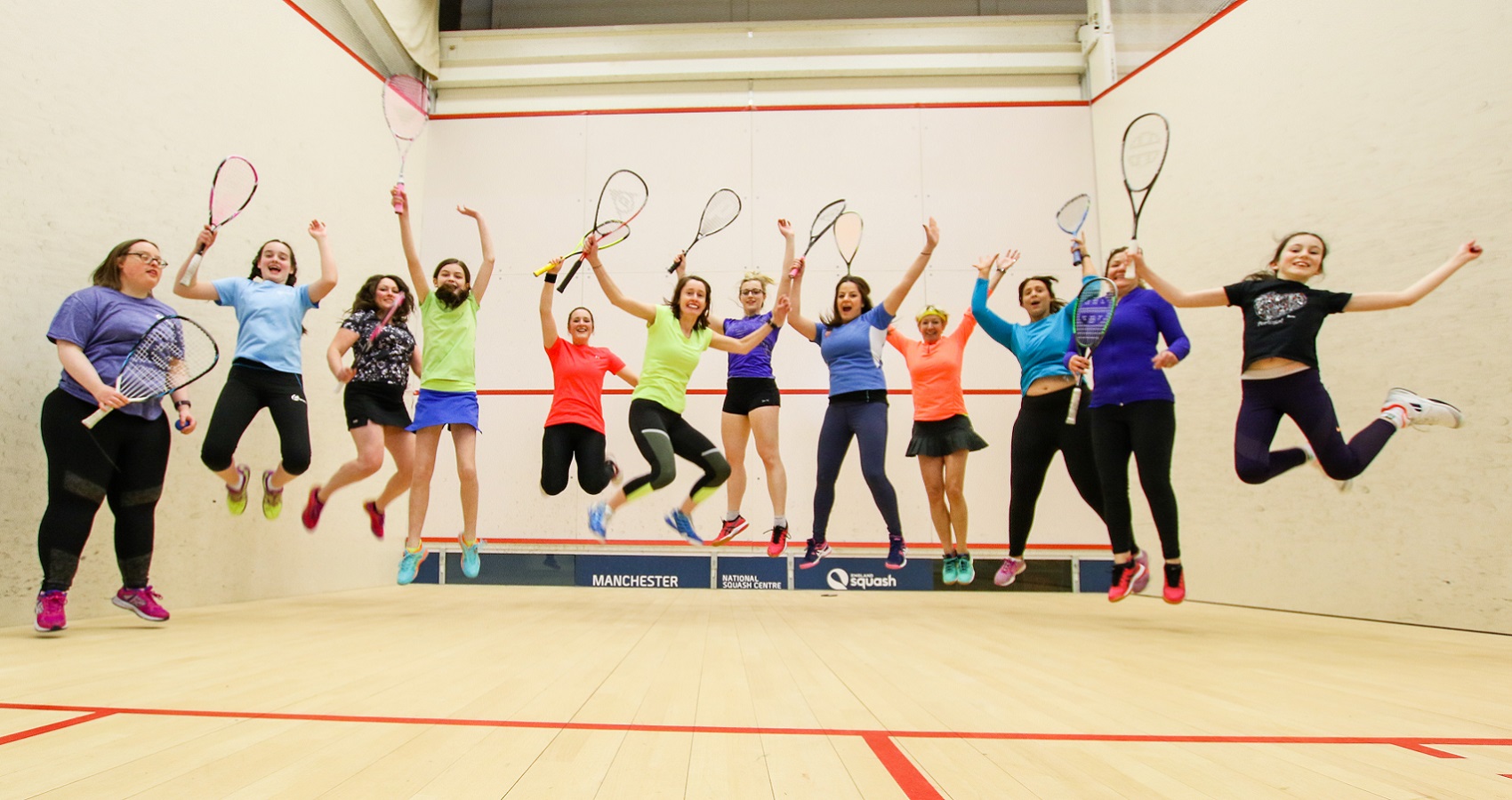 Group of female squash players jumping in the air