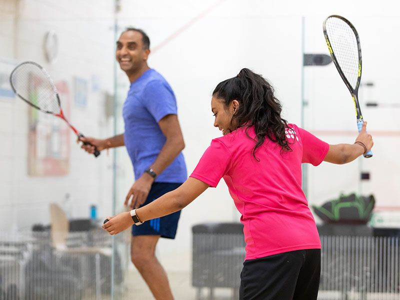 Man and woman playing squash